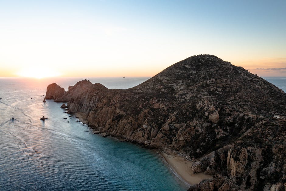 Stunning aerial view of rocky coastline and sunset in Cabo San Lucas, Mexico.